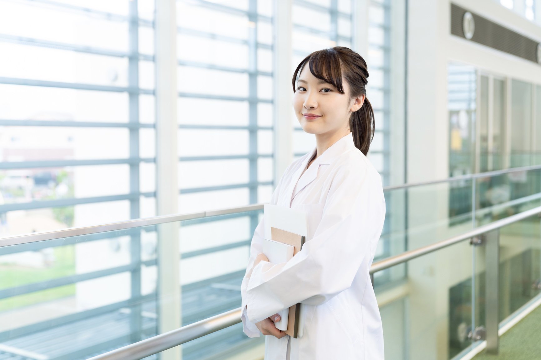 Young asian woman wearing a white robe. Medical school student. Science school student.