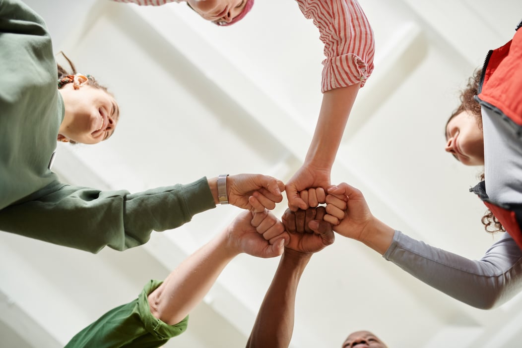 People in Circle Formation Doing Fist Bump